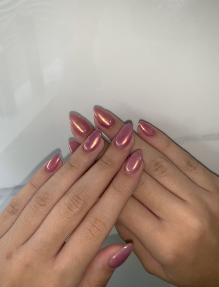 Elegant Glowing Ombre Almond Nails in Soft Pink and Rosy Metallic Finishes.