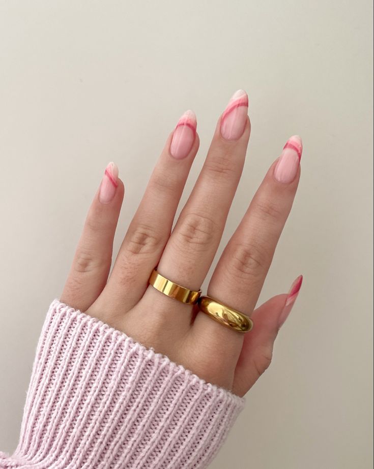 Chic Soft Pink and Red Tip Nails with Whimsical Lines and Gold Accents.