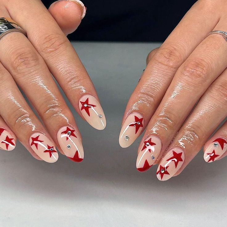 Chic Nude and Red Nail Design with Star Accents and Rhinestones