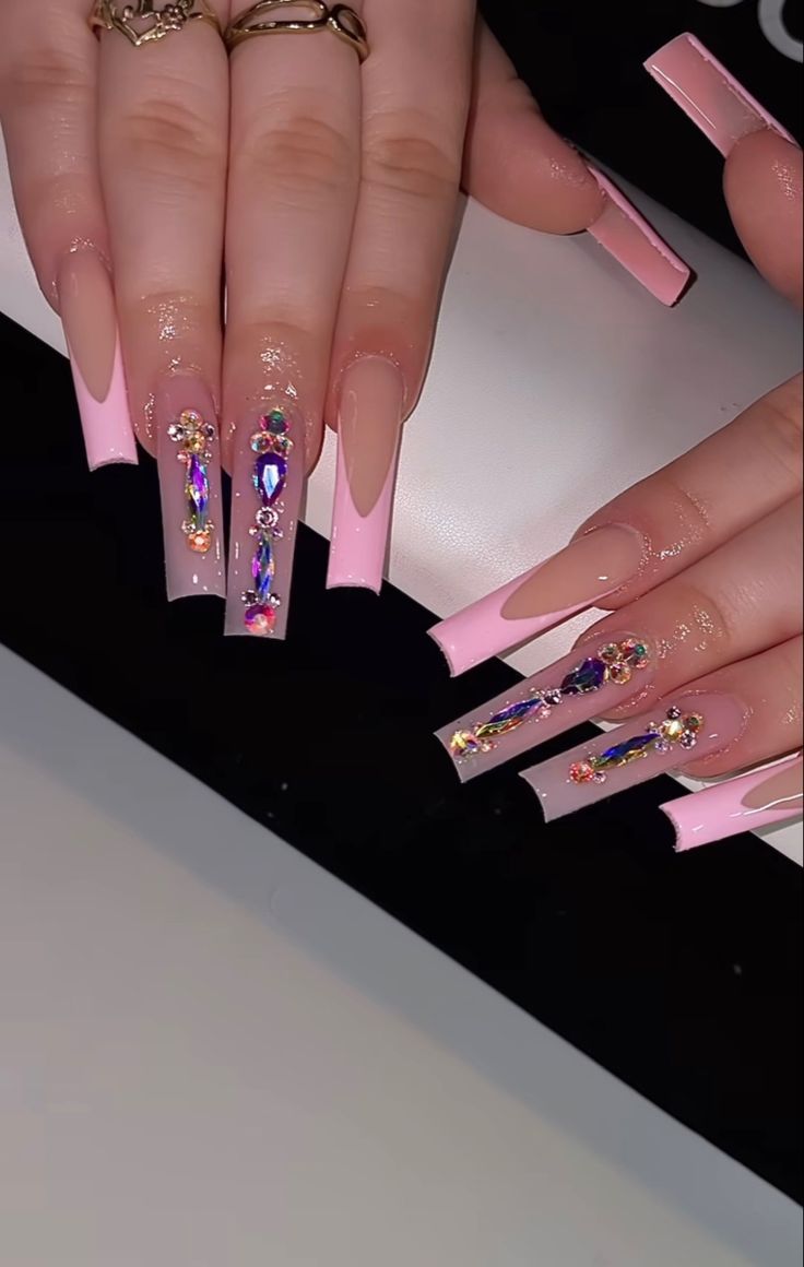 Sophisticated Nail Design: Soft Pink and Clear Acrylics with Vibrant Gemstone Accents.