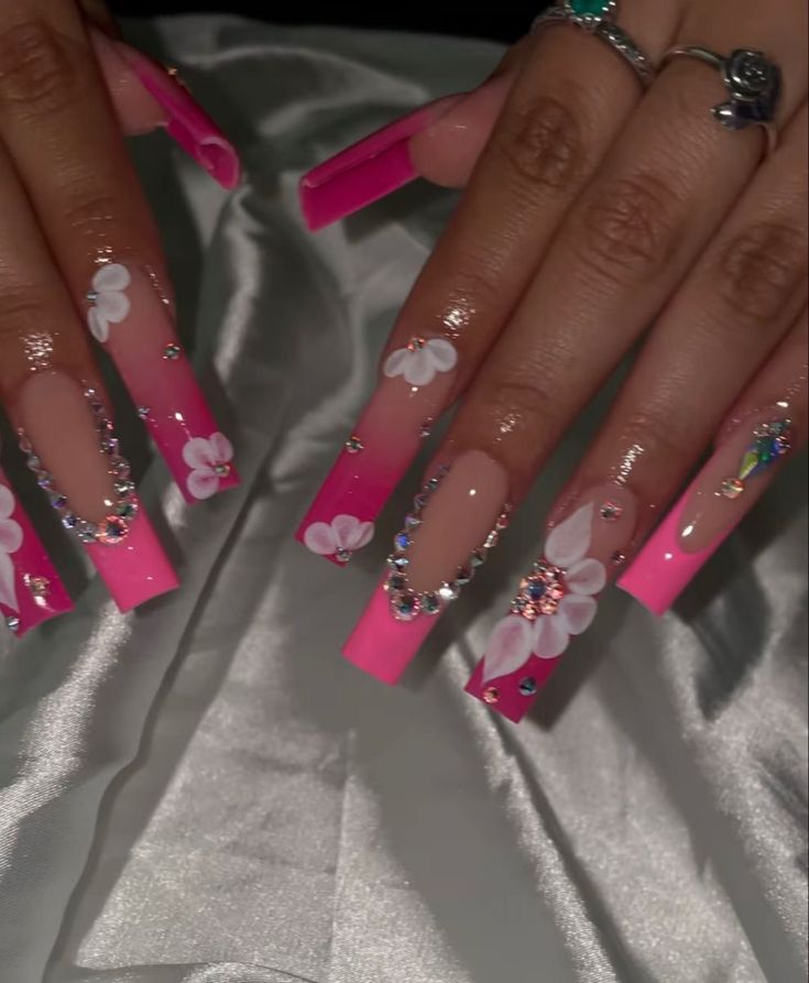 Glamorous Elongated Tip Nail Design: Pink Gradient, Floral Patterns, and Sparkling Rhinestones.