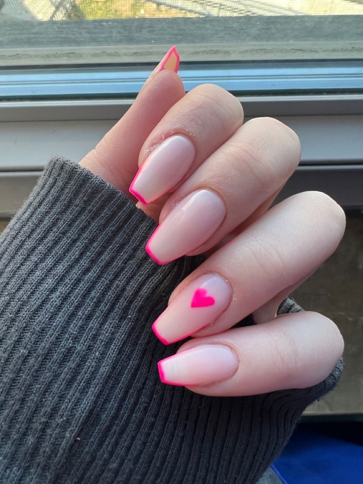 Chic Nail Design: Soft Pink Base with Vibrant Tips and a Heart Accent.