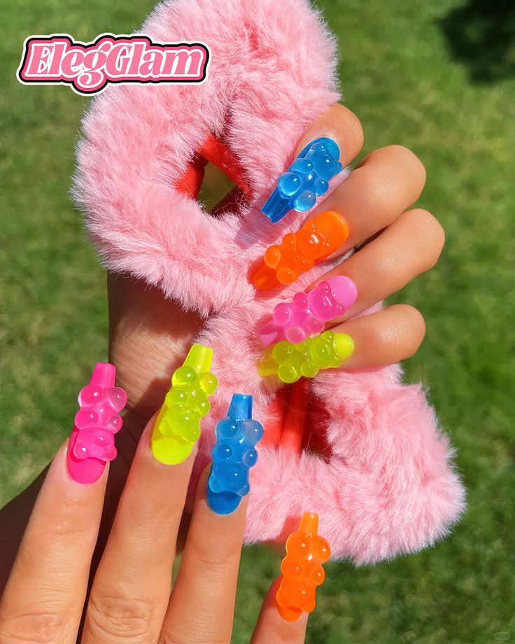 Playful Coffin-Shaped Nail Art with Colorful Gummy Bear Accents and Fluffy Pink Accessory.