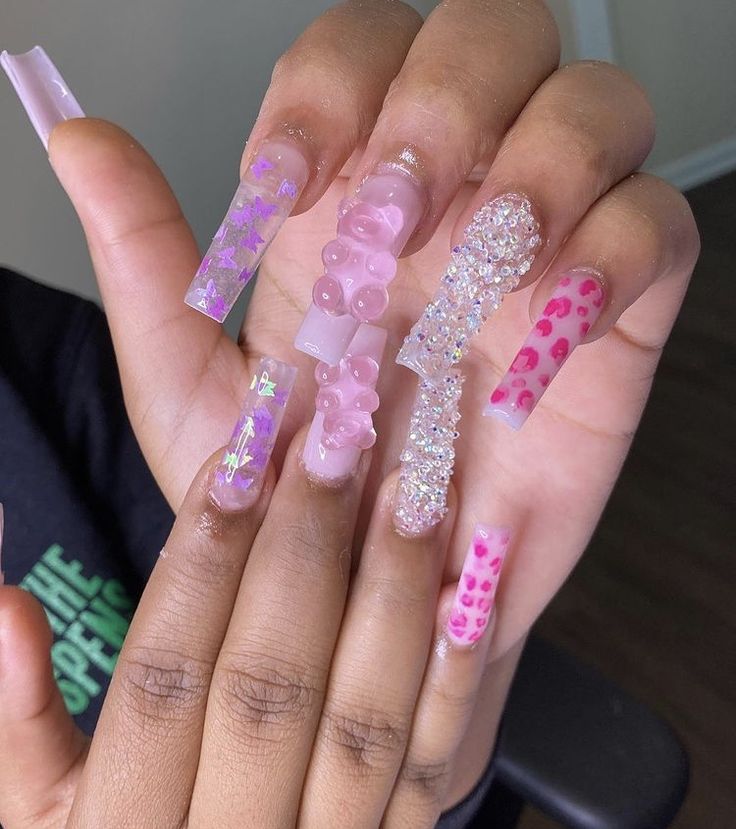 Playful Trendy Nail Design with Light Pink Shades and Whimsical Embellishments.