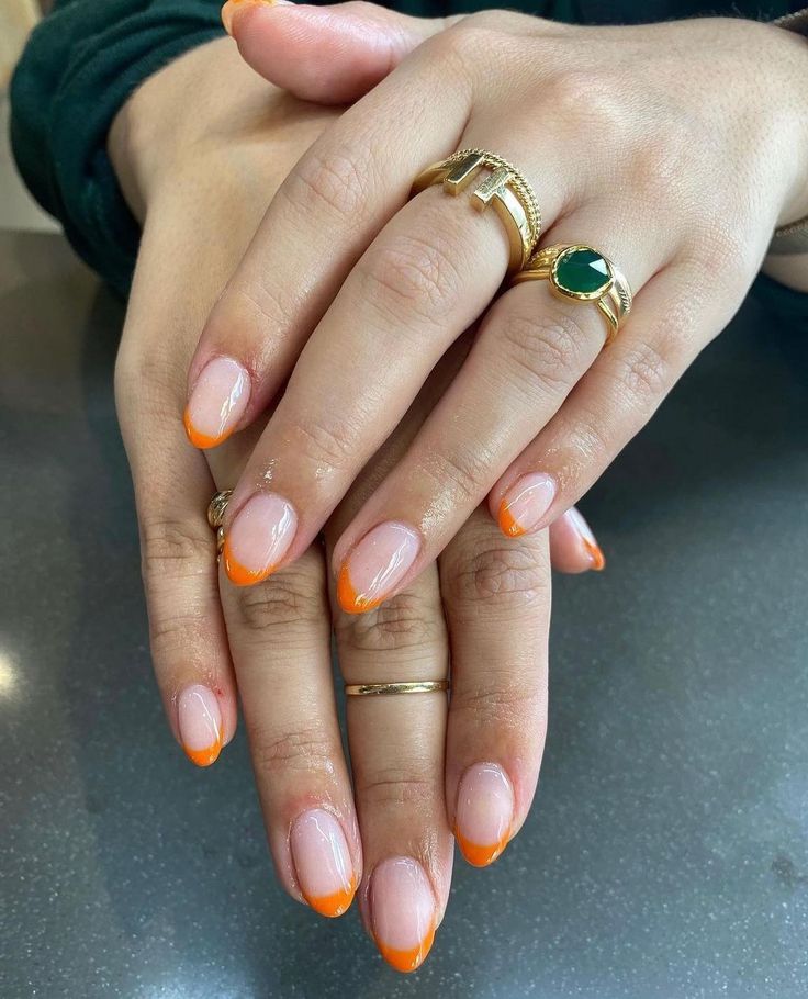 Chic Nail Design: Natural Base with Vibrant Orange Tips for a Modern French Manicure.