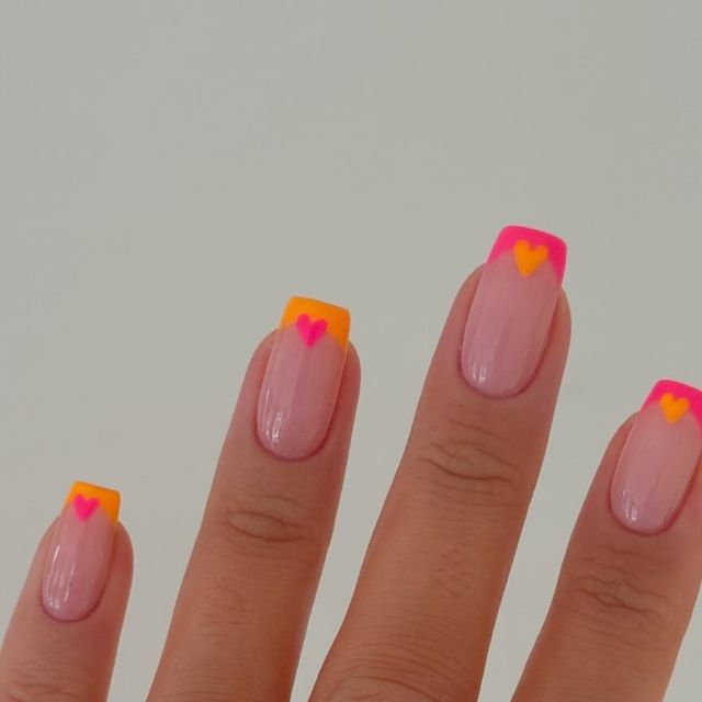 Chic Nail Designs Featuring Colorful Heart Accents on a Pale Pink Base