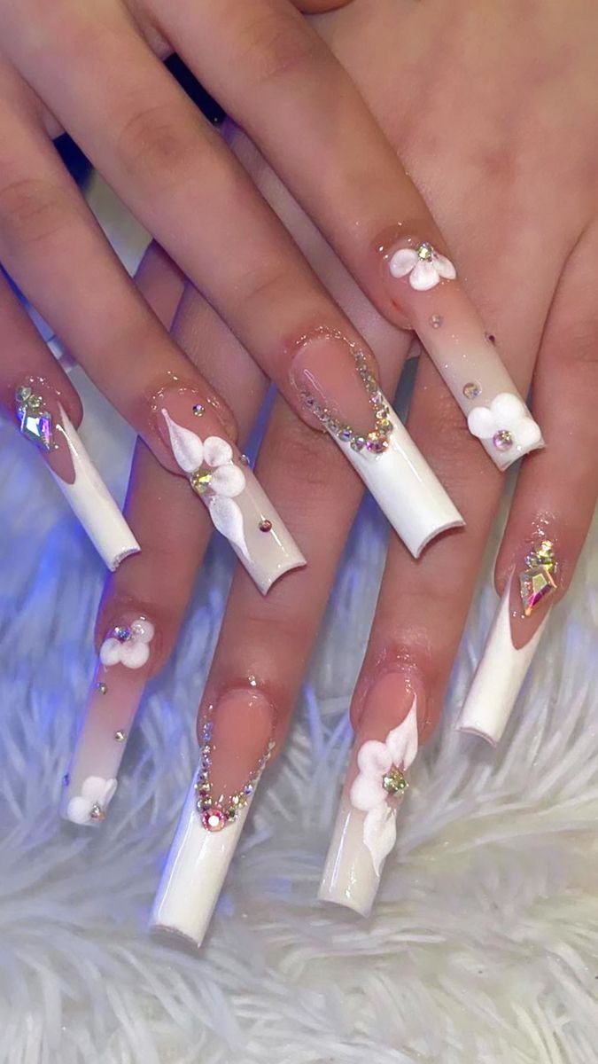 Chic Long Square Nail Design with Glossy White Finish, Floral Accents, and Rhinestones.