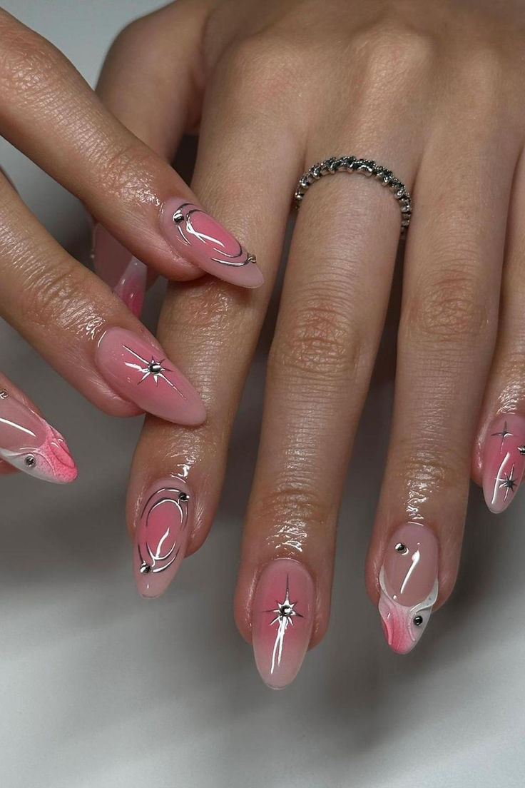 Sophisticated Nail Design: Soft Pink and Glossy White with Intricate Swirls and Gem Accents.