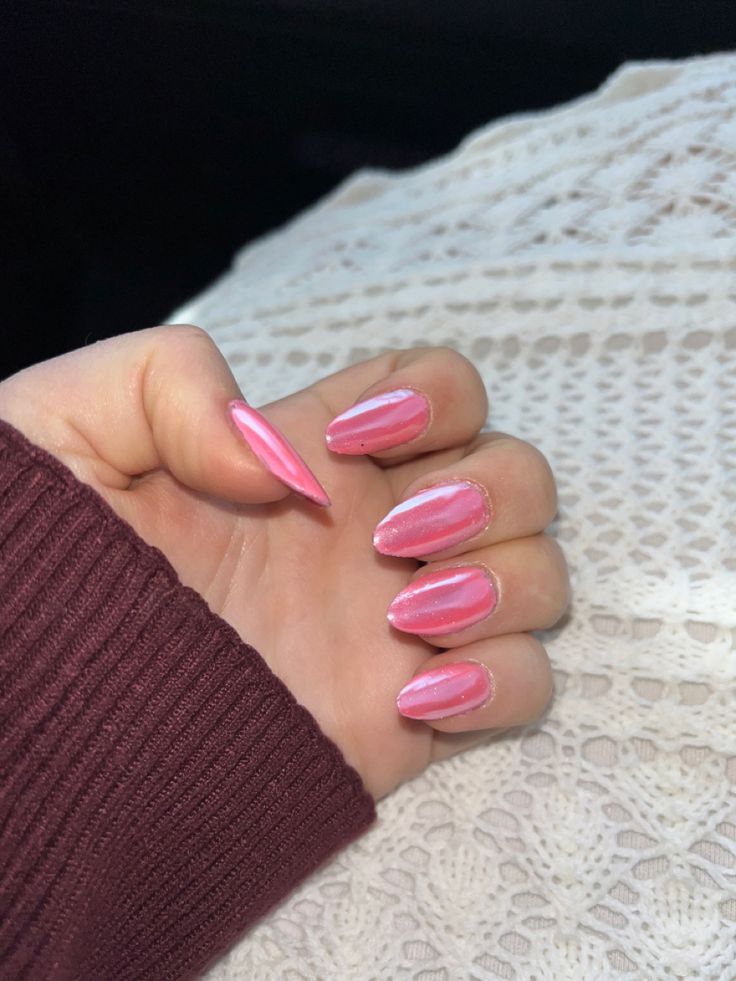 Beautiful Elegant Pink Almond-Shaped Manicure with Glossy Finish and Cozy Background.