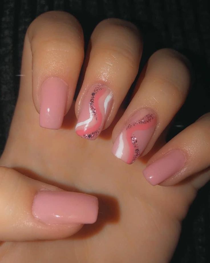 Chic Soft Pink Nail Design with White Wavy Accents and Glitter Sparkle.