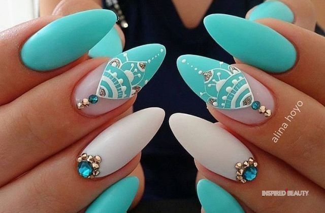 Sophisticated Turquoise and White Nail Design with Intricate Patterns and Sparkling Embellishments.