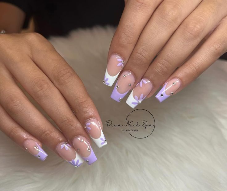 Chic Lavender Nail Design with Classic French Tips and Floral Embellishments.