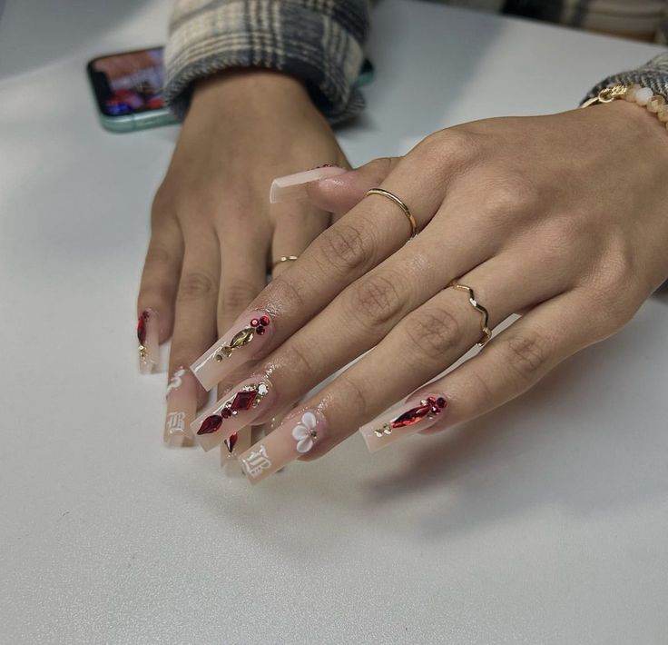 Elegant Nail Design: Soft Pink and Striking Red with Floral Patterns and Shimmering Accents