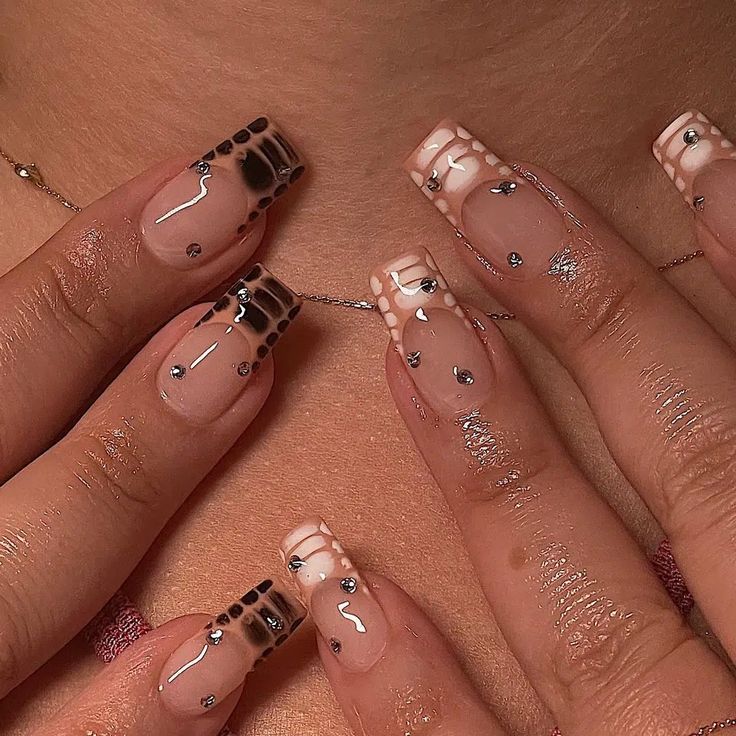 Sophisticated Nude and Black Nail Design with Rhinestones for a Bold yet Delicate Look.