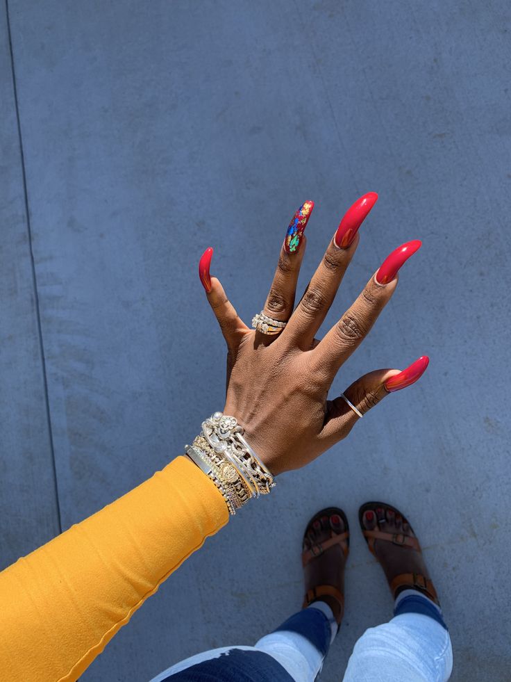 Elegant Red Nail Design Enhanced by Colorful Art and Gold Bracelets.