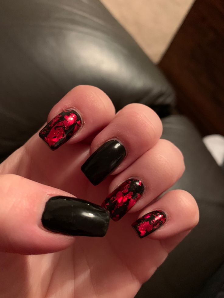 Striking Elegant Nail Design: Glossy Black with Vibrant Red Marble Accents.