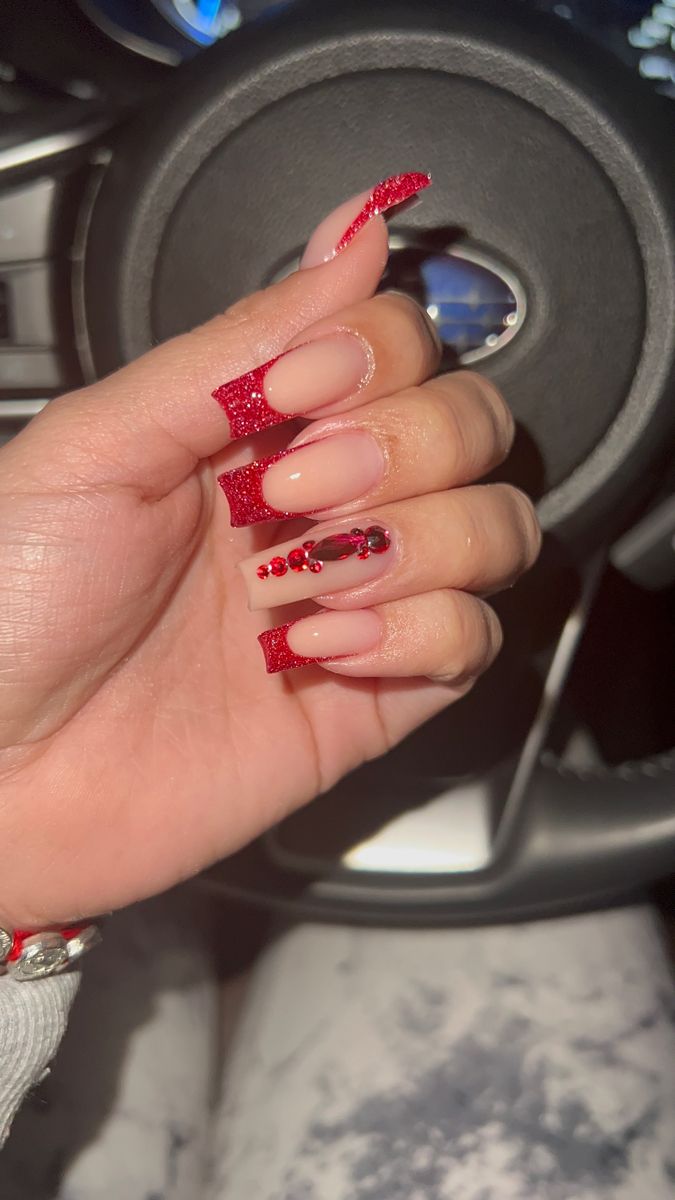 Elegant Nail Design: Striking Nude and Red Combo with Glitter and Rhinestone Accents.