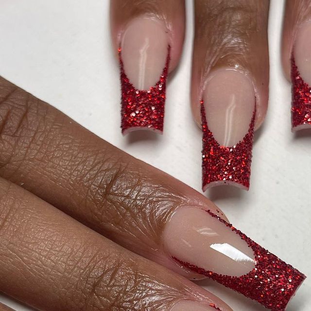 Vibrant Red Glitter Tips Elevate Classic French Manicure with Glamorous Sophistication.