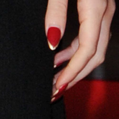 Chic Red Nails with Bold Dipped French Tips and Gold Accents.