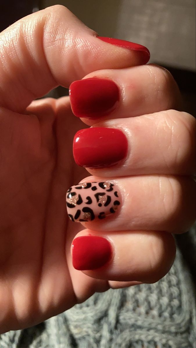 Elegant Red Nail Design with Bold Leopard Print Accent.