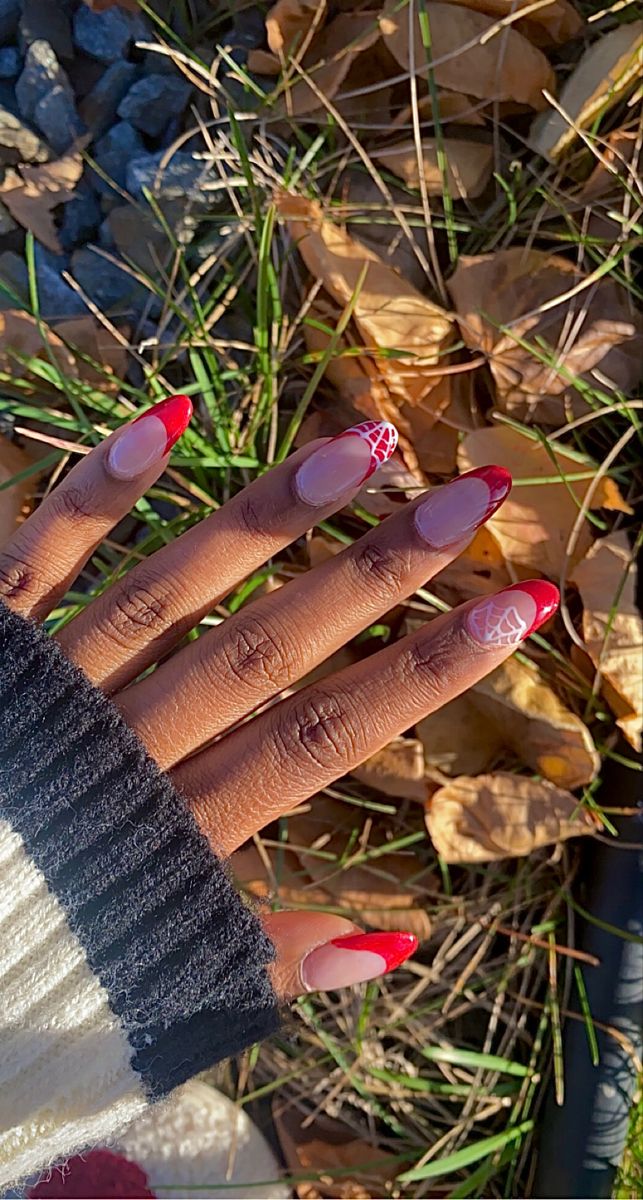 Autumn-Inspired Elegant Red and Nude Nail Design with Striking French Tips and Intricate White Web Patterns.