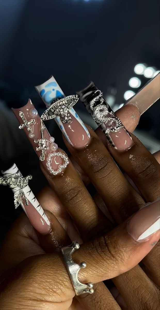 Trendy Elegant Nail Designs: Intricate Textures and Silver Charms on Nude Bases.