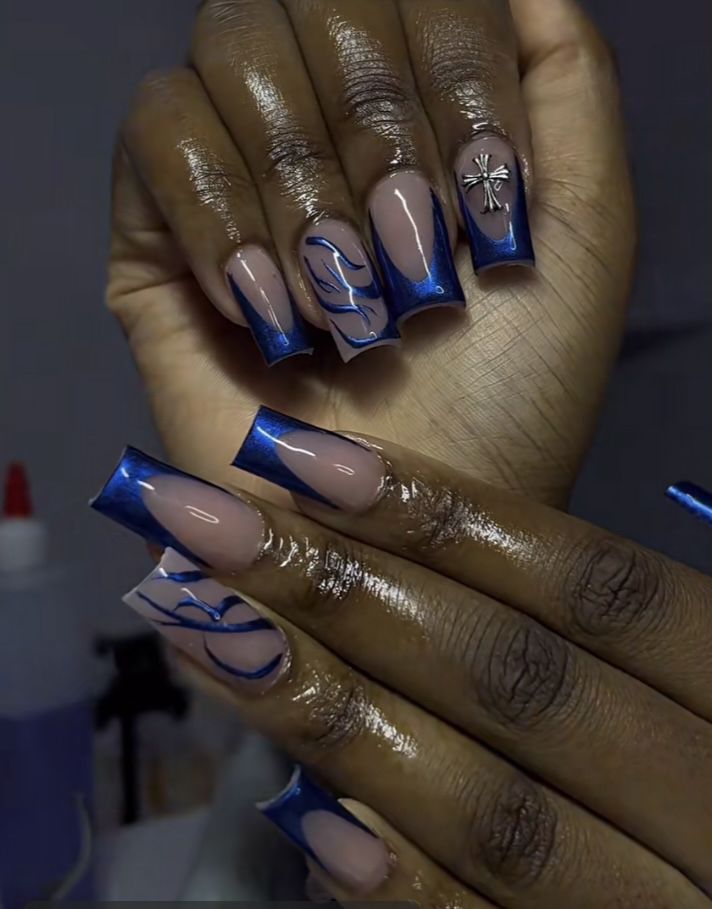 Sophisticated Nail Art: Elegant Nude and Deep Blue Design with Marbled Swirls and Decorative Embellishment.