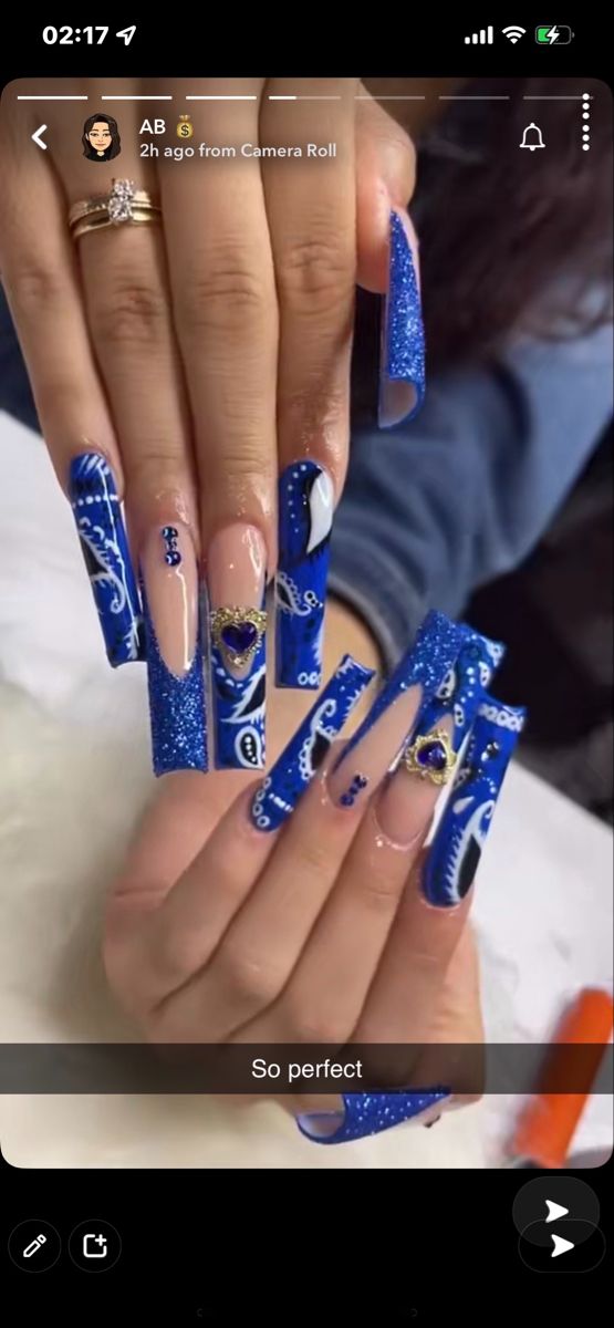 Stunning Blue Coffin Nails with Glitter, Elegant Patterns, and Rhinestone Accents.