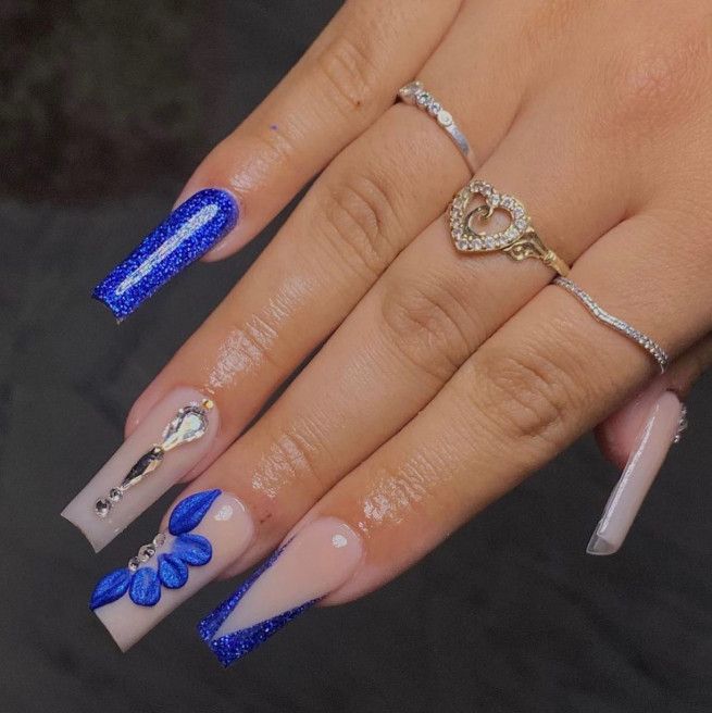 Stunning Blue and Nude Nail Design with Glossy Finishes and Elegant Embellishments.