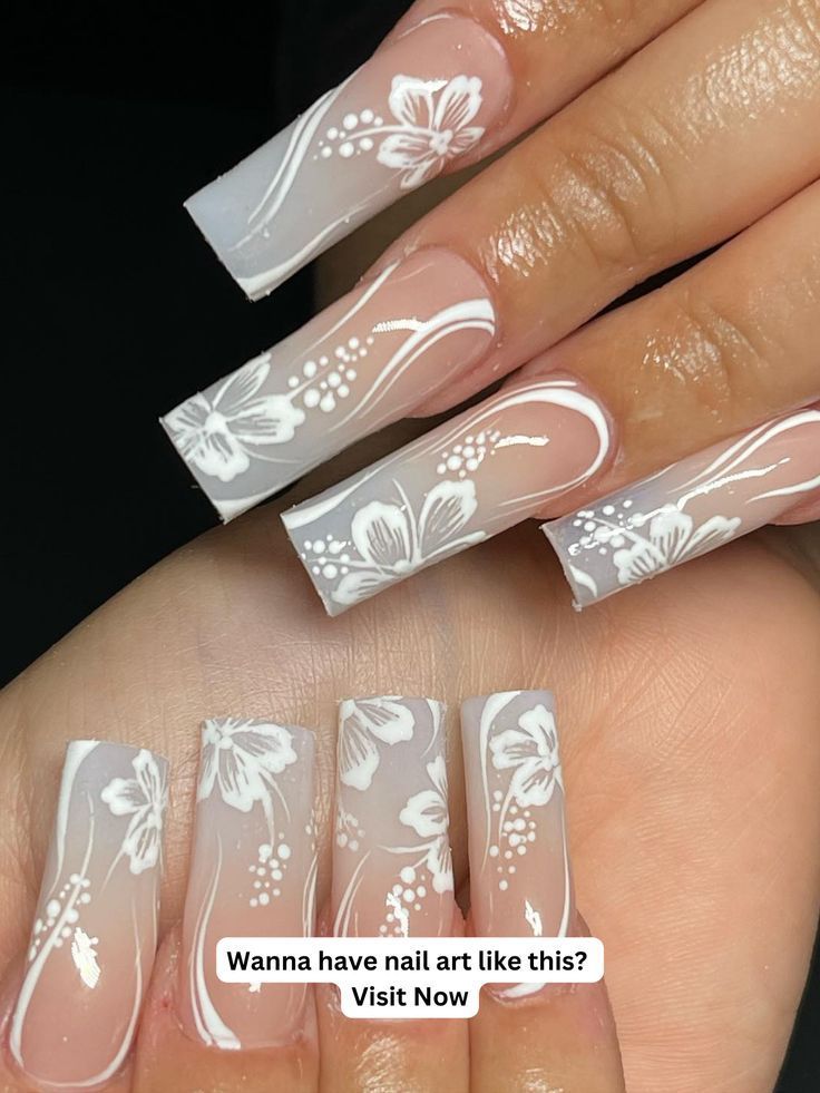 Elegant Floral Nail Art: Intricate White Patterns on Translucent Base