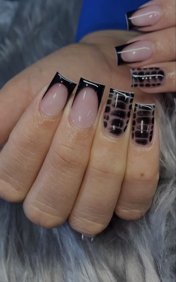 Elegant Nail Design: Glossy Black Tips with Unique Patterns Enhance a Natural Nude Base.