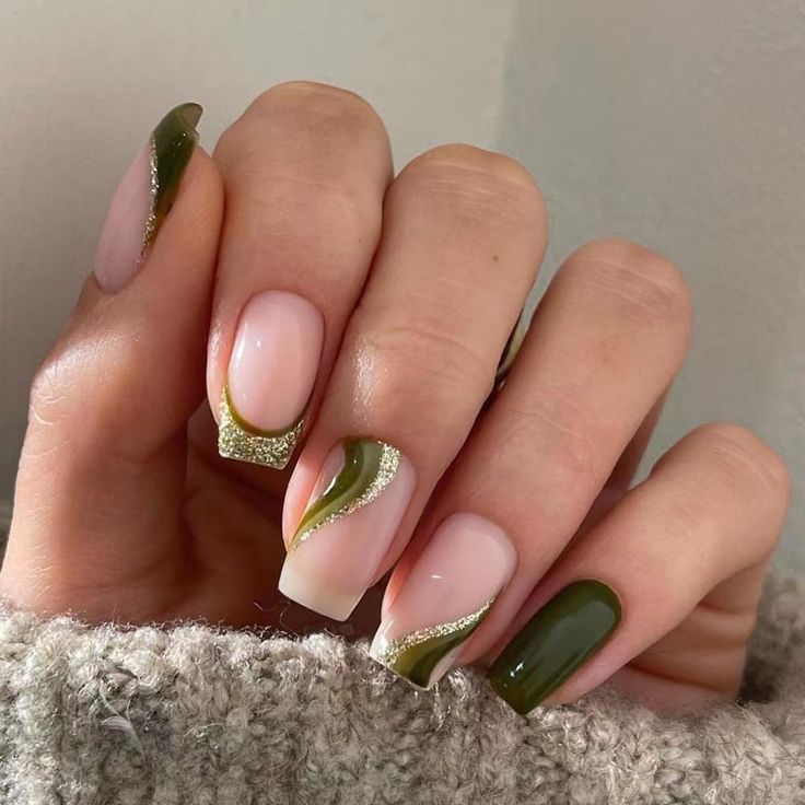 Chic Nail Design: Soft Nude and Rich Green with Artistic Swirls and Golden Accents.