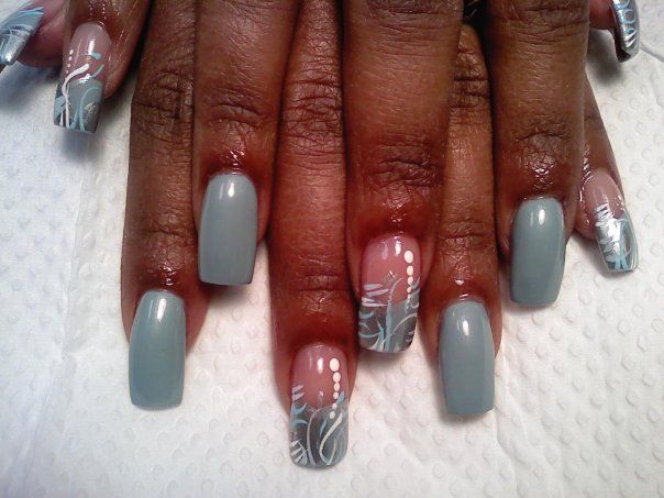 Sophisticated Nail Design: Soft Gray and Nude Shades with Intricate White Patterns.