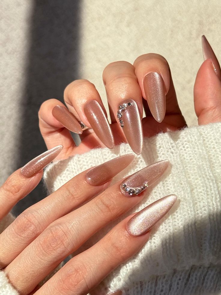 Elegant Almond-Shaped Nails in Soft Nude with Shimmer and Rhinestone Accents