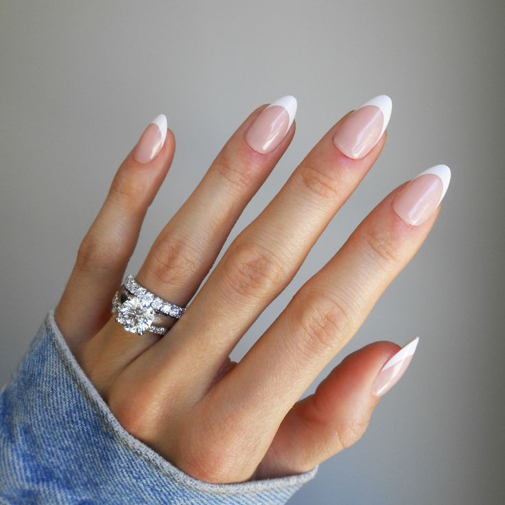 Timeless Elegance: Sophisticated French Tip Nails with Almond Shape and Stylish Accessories.