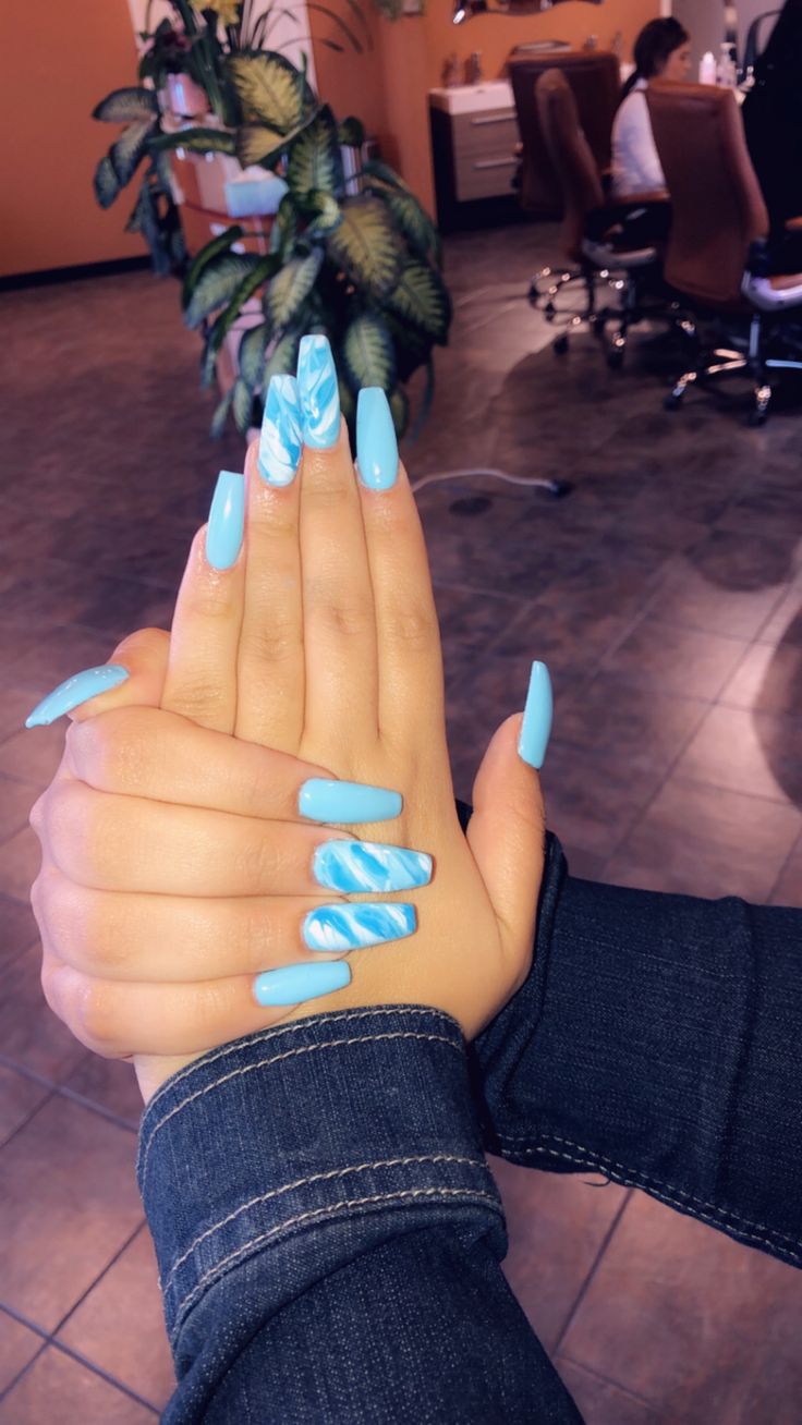 Bold and Playful Vibrant Blue Nail Design with Artistic Marble Accents.