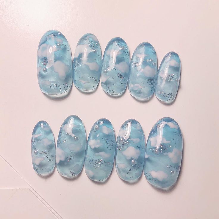 Whimsical Light Blue Cloud-Patterned Nails with Sparkling Glitter Accents