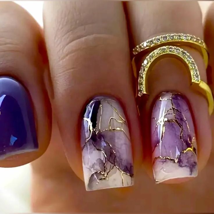 Elegant Deep Purple and Marble Nail Design with Artistic Gold Accents