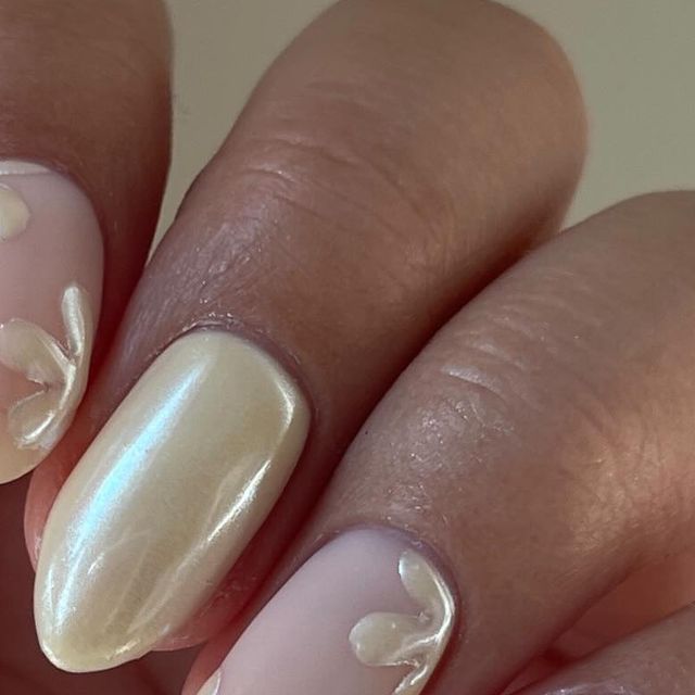 Elegant Floral Nail Design with Creamy Base and Minimalist Patterns.