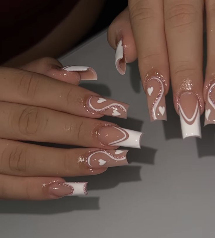 Elegant Nude and White Nail Design with Heart Patterns and Shimmering Accents