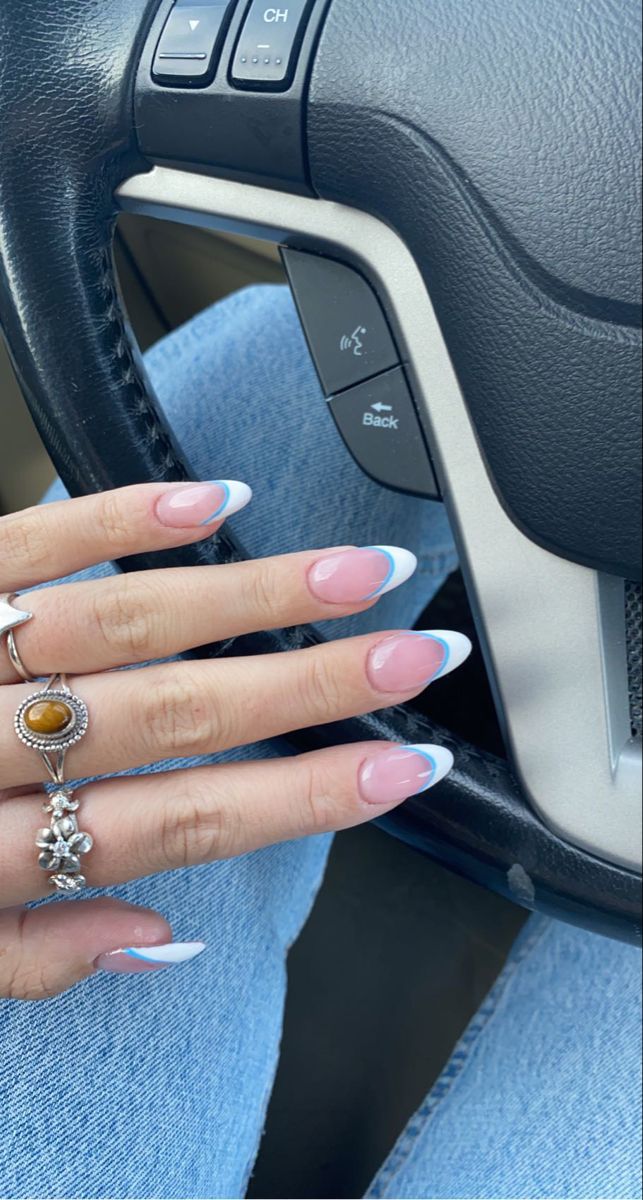 Chic French Manicure with Vibrant Blue Tips and Delicate Rings.