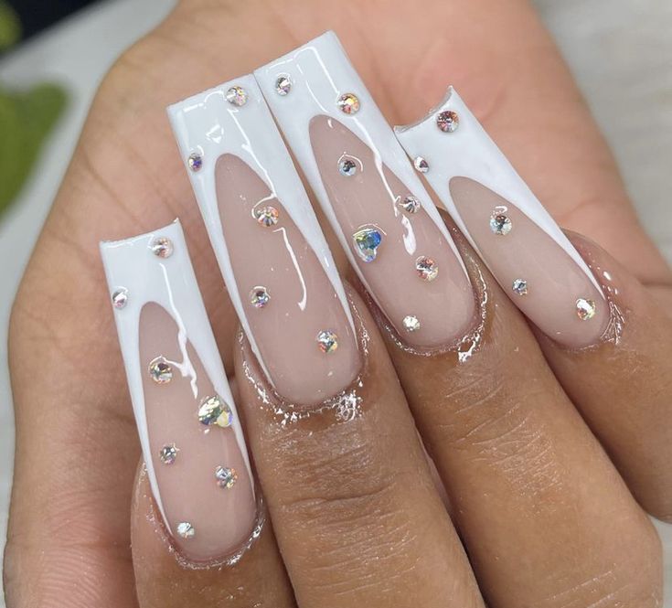 Chic Nail Design: Glossy White Tips, Sheer Nude Base, and Glamorous Rhinestone Accents.