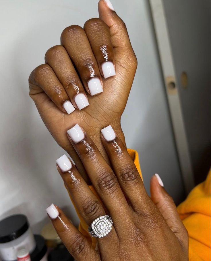 Elegant Soft White Nail Design with Modern Square Shape and Statement Ring.