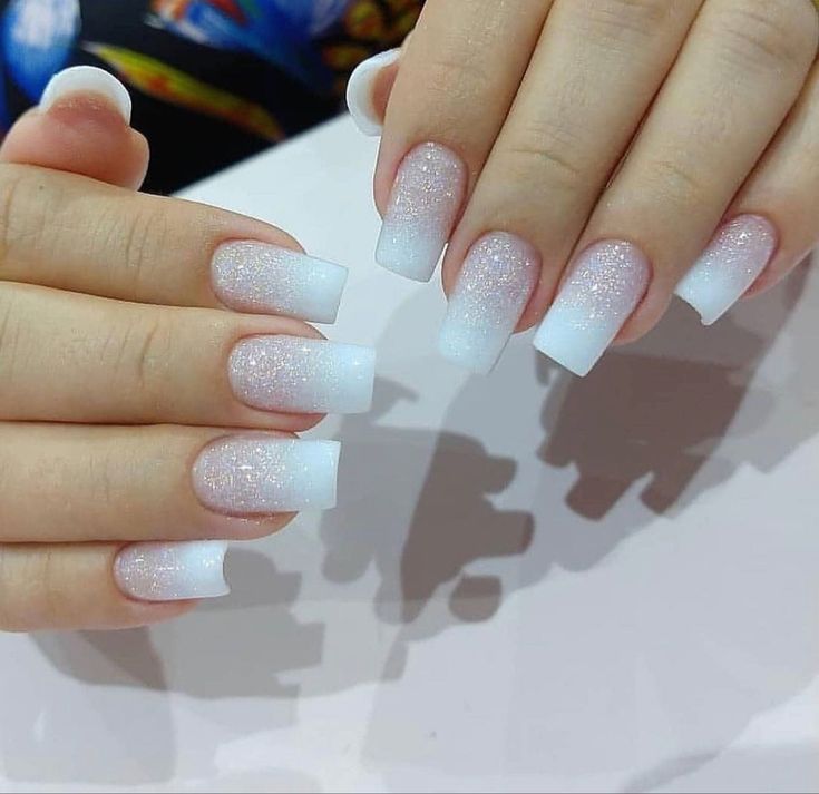 Elegant Ombre Nails: Soft Pink to White Gradient with Sparkling Glitter and Modern Square Tips.