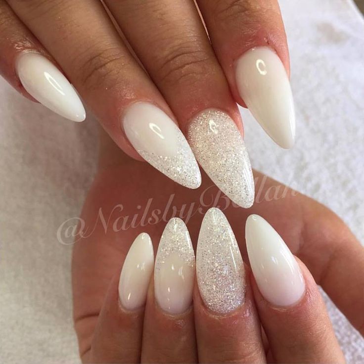 Sophisticated Almond-Shaped Nails with Pristine White Polish and Silver Glitter Accents.