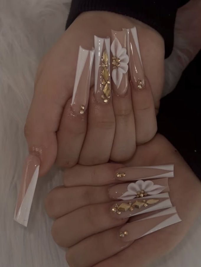 Chic Translucent Nail Design with Bold White Accents and Gold Floral Embellishments.