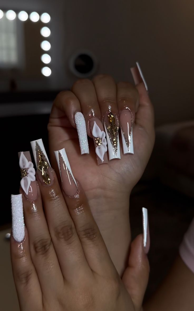 Chic Elegant Nail Design: Long Sharp Tips with Glossy Nude, White Tips, Floral Embellishments, and Glitter Accents.