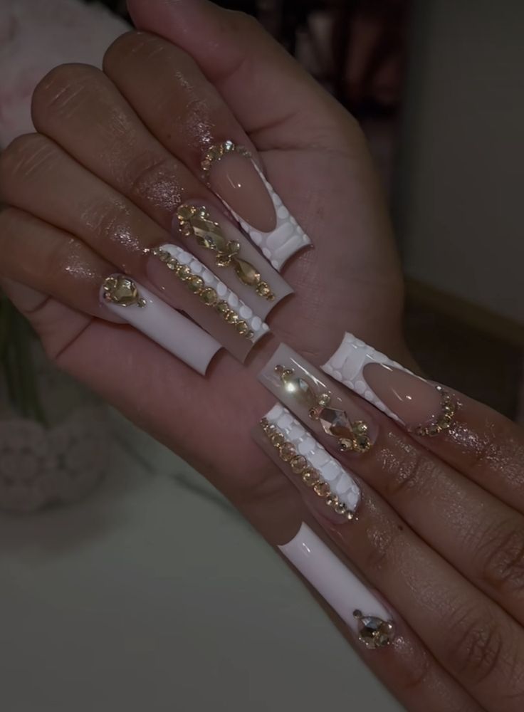 Luxurious Almond-Shaped Nail Design with Glossy White, Nude Shades, and Gold Rhinestones.