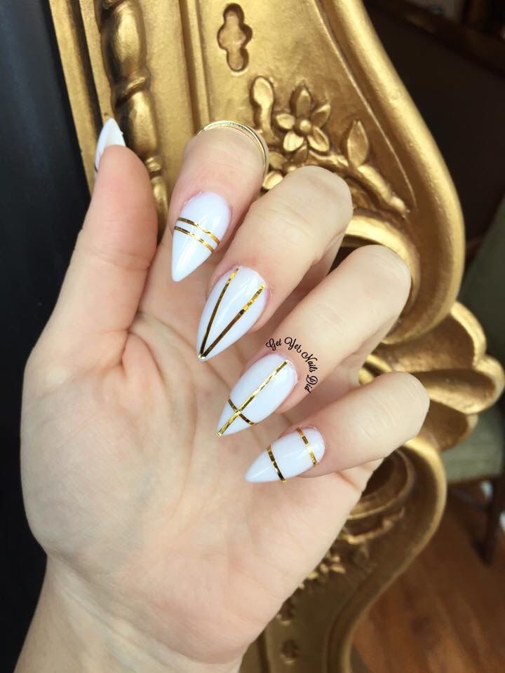 Sophisticated Elegant Stiletto Nails with Pristine White and Metallic Gold Stripes.