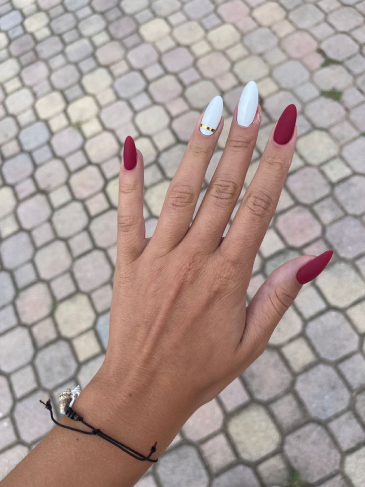 Chic Almond-Shaped Nails: Striking Burgundy and White Design with Elegant Embellishment.